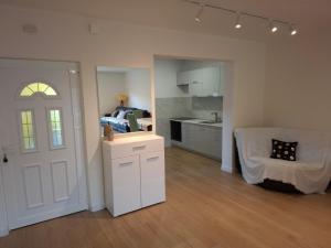 a living room with a kitchen and a white door at Sunrise Apartment in Igalo