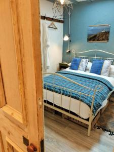 ein Schlafzimmer mit einem Bett mit blauen Wänden in der Unterkunft Cattle Shed Cottage in Narberth