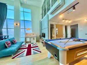 a living room with a pool table and a couch at Maritime Suite #Full Seaview with sunrise #Pool Table #Water filter machine #Georgetown #6pax duplex unit #Private host in Jelutong