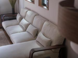 eine weiße Couch mit Kissen in einem Wohnzimmer in der Unterkunft GOHO STAY me Sumiyoshi in Tokio