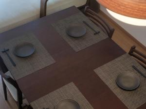 ein Holztisch mit drei Tellern darauf in der Unterkunft GOHO STAY me Sumiyoshi in Tokio + 43 Fotos