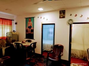 a room with a table and a clock on the wall at Ima Apartment in Galle