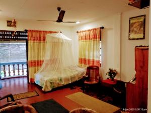 a bedroom with a bed with a mosquito net at Ima Apartment in Galle