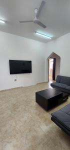 a living room with two beds and a flat screen tv at Hasik Beachfront Apartments in Ḩaḑbaram +7 photos
