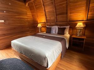 a bedroom with two beds in a wooden cabin at eM eR GLAMPING & VILLAS in Bedugul