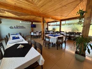 a restaurant with tables and chairs in a room at Hotel Amatista in Wanda