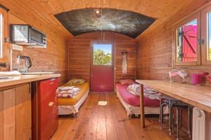 a room with a kitchen and a table in a cabin at Roulotte Ferme Saint-Pierre in Bargème