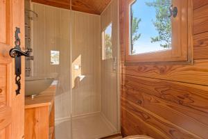 a bathroom with a sink and a glass shower at Roulotte Ferme Saint-Pierre in Bargème