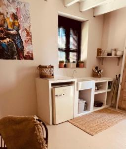 a kitchen with a counter and a sink and a window at Le Brasseur Logements in Saint-Caprais