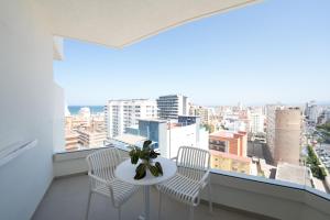 a balcony with a table and chairs and a view of the city at Hotel RH Arena - Todo Incluido in Gandía