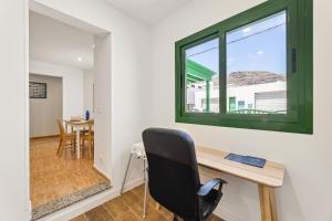 a office with a desk and a window at Home2Book Relaxing Órzola Getaway with BBQ in Orzola