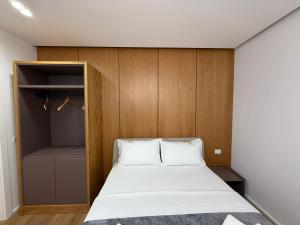 a small bedroom with a bed and a closet at Maper in Pogradec