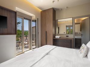 a bedroom with a large bed and a balcony at Villa Portokalea in Maleme +48 photos