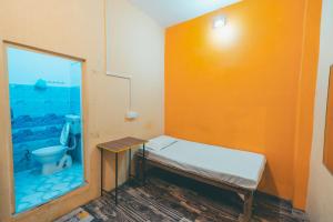 a small room with a bed and a window at Om Rest House by Bunny Cafe Varanasi in Varanasi