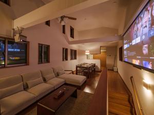 ein Wohnzimmer mit Sofa und Flachbildfernseher in der Unterkunft GOHO STAY me Sumiyoshi in Tokio