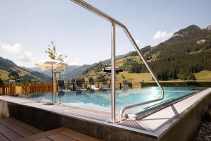 a swimming pool with a view of mountains at Hotel Dorfer in Grossarl