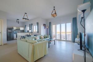 Una sala de estar con un sofá y una cocina. en Luxury 3 Bedroom Apt. in El Gouna with amazing view, en Hurghada