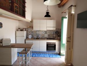 a kitchen with white cabinets and a wooden table at Da Massimo in Cefalù