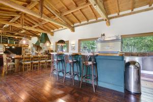 a kitchen with wooden floors and a bar with stools at Cà Bossi Retreat above Lake Como in Cernobbio