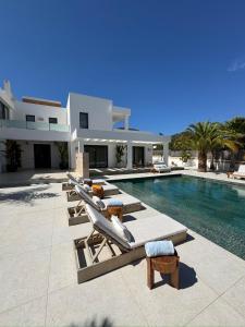 a swimming pool with lounge chairs and a villa at Villa Elísea in Ibiza Town
