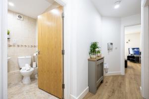 a bathroom with a toilet and a sink at Stylish 2-Bed Apartment in Manchester City Centre in Manchester +11 photos