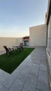a patio with a table and benches on a building at شقة بالدور الثالث in Quai