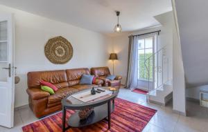 een woonkamer met een leren bank en een tafel bij Nice Home In Saint-Georges-D'oléron in Saint-Georges-dʼOléron