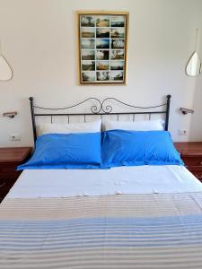 a bed with blue pillows in a bedroom at Al Poggetto in Gradoli