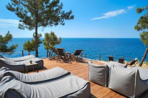 un patio avec des chaises et une vue sur l'océan dans l'établissement Acroterra - Easy Living, à Alikí