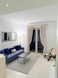 a living room with a blue couch and a table at Porto Marina Residence in Tivat