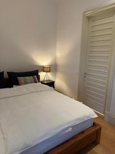 a bedroom with a large white bed and a lamp at Porto Marina Residence in Tivat