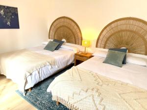 ein Zimmer mit zwei Betten und einem Tisch mit einer Lampe in der Unterkunft Maison Palomase en plein cœur de Sancerre in Sancerre