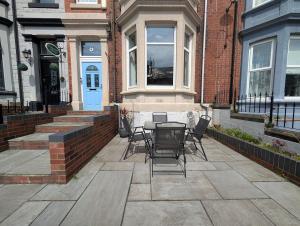 a patio with a table and chairs in front of a building at Deskie House in Newcastle upon Tyne +5 photos