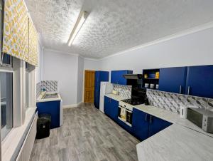 a blue and white kitchen with blue cabinets at Deskie House in Newcastle upon Tyne