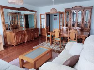 un soggiorno con un divano bianco e un tavolo di Apartamento en Cee a Cee 1 altra foto