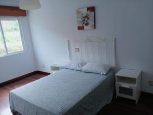 una camera da letto con un letto e una finestra di Apartamento en Cee a Cee