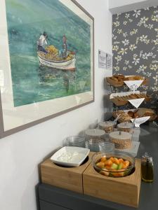 a table with a plate of fruit and a painting at Aliston Hotel Thassos in Skala Potamias