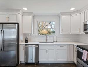 a kitchen with white cabinets and a stainless steel refrigerator at Franklin Retreat - Sleeps 4 in Franklin +10 photos