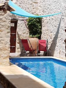 a patio with two chairs and a swimming pool at Casa Sastre Segui in Patró