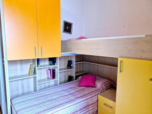 una piccola camera con letto a castello e armadi gialli di Villa Sandra a Bibione