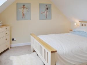 a bedroom with a bed and two pictures on the wall at Dairy Cottage in Matfield