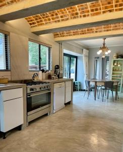 a kitchen with a stove and a table with chairs at Underberg - The Burn - Solar Powered in Underberg