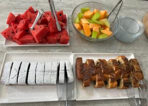 a table with two plates of food with watermelon and fruit at Aliston Hotel Thassos in Skala Potamias
