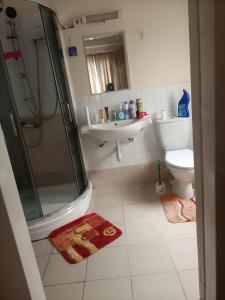 une salle de bains avec douche, lavabo et toilettes dans l'établissement Thalia Appartement, à Nairobi