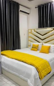 MamaにあるGolden tulip apartmentのベッドルーム1室(大型ベッド1台、黄色い枕付)