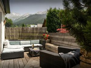 a patio with a couch and chairs on a deck at Chalet Le Petit Mazot - OVO Network in La Clusaz +14 photos