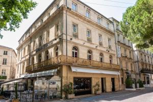 an old building on the corner of a street at Hôtel de l'Horloge in Avignon