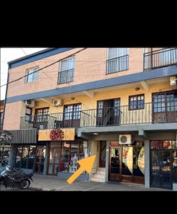 a building with an orange arrow in front of it at Pequeño Monoambiente céntrico 1E in Puerto Iguazú
