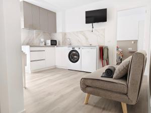 a living room with a washing machine and a couch at Pes Na Area Fisterra 12 in San Martín de Arriba