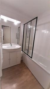 a white bathroom with a sink and a shower at La Merlerie Super-Besse agréable appartement 5p grand balcon parking privé in Besse-et-Saint-Anastaise